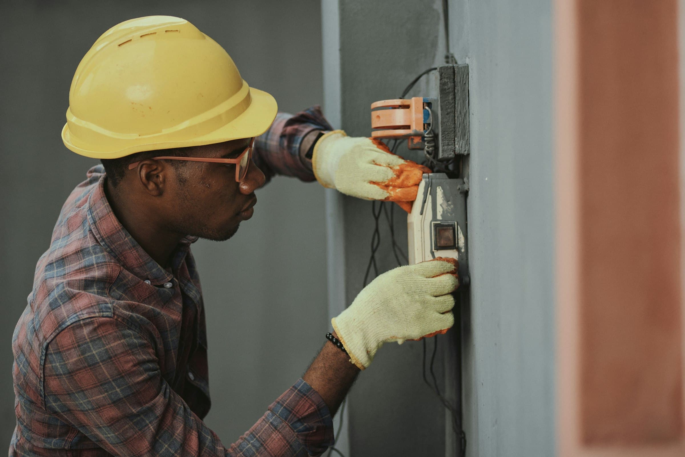 An Arcfield electrician wiring an external meter box